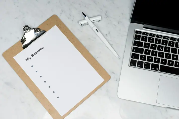 Laptop and notes on a desk beside a dog